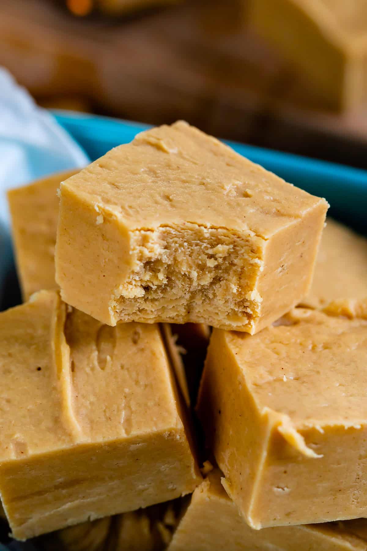 pile of fudge squares in teal container with bite missing