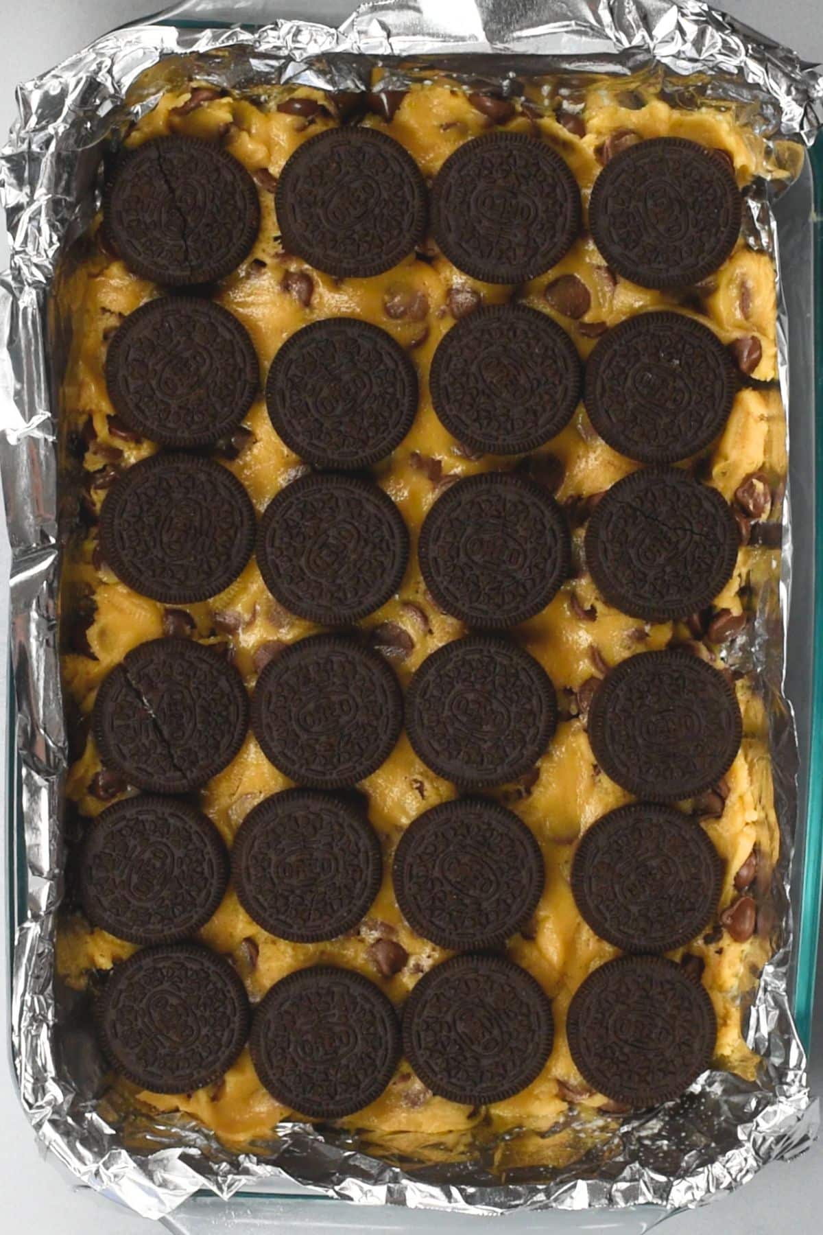 cookie dough in pan topped with Oreos.