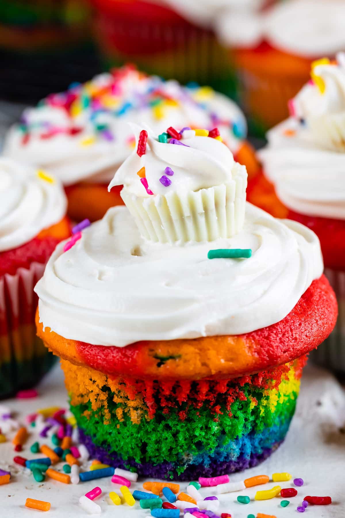 rainbow cupcake with white frosting and white Reese's on top