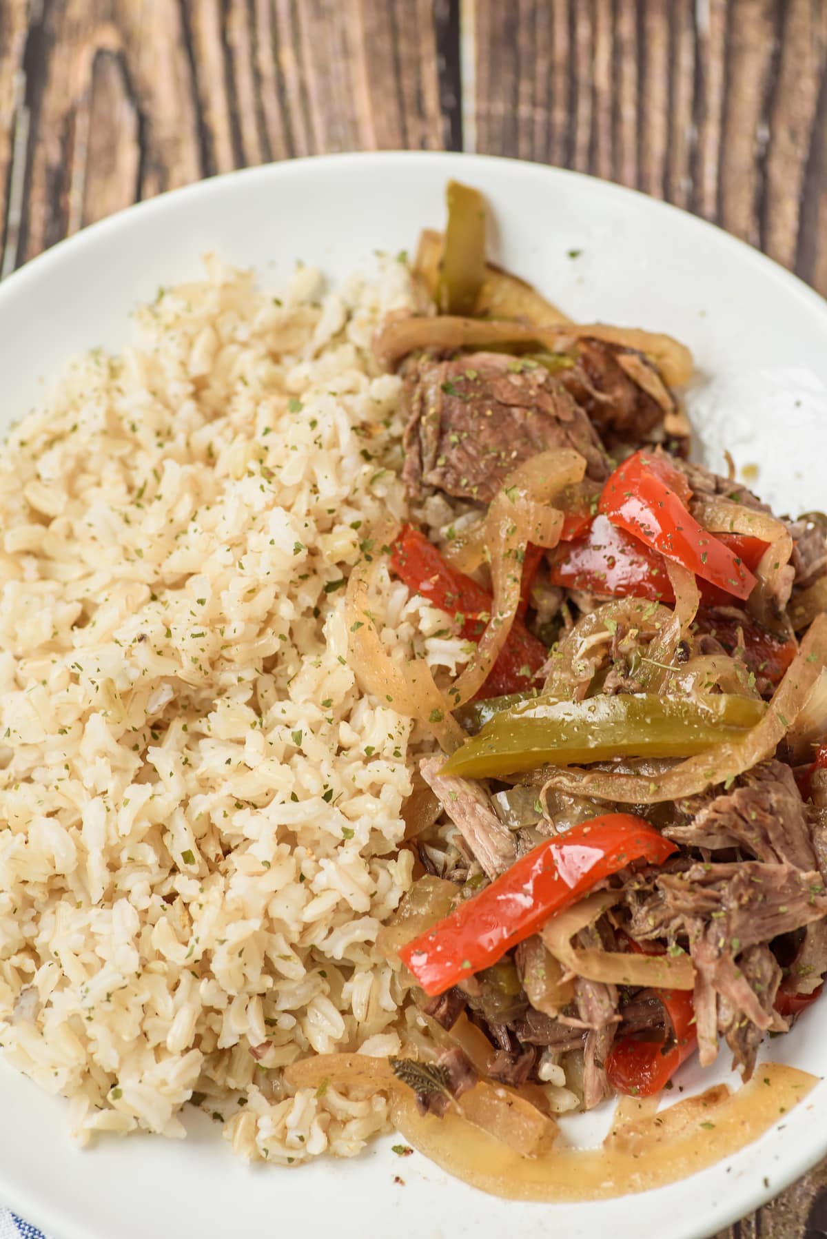 peppers and steak on white plate with rice and fork