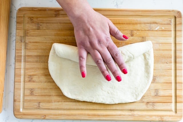 hand rolling up bread dough