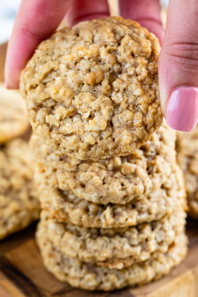 stack of oatmeal cookies with hand picking up one