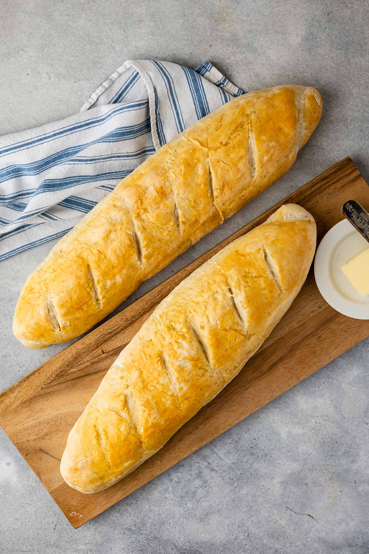 2 loves of bread with cutting board and napkin