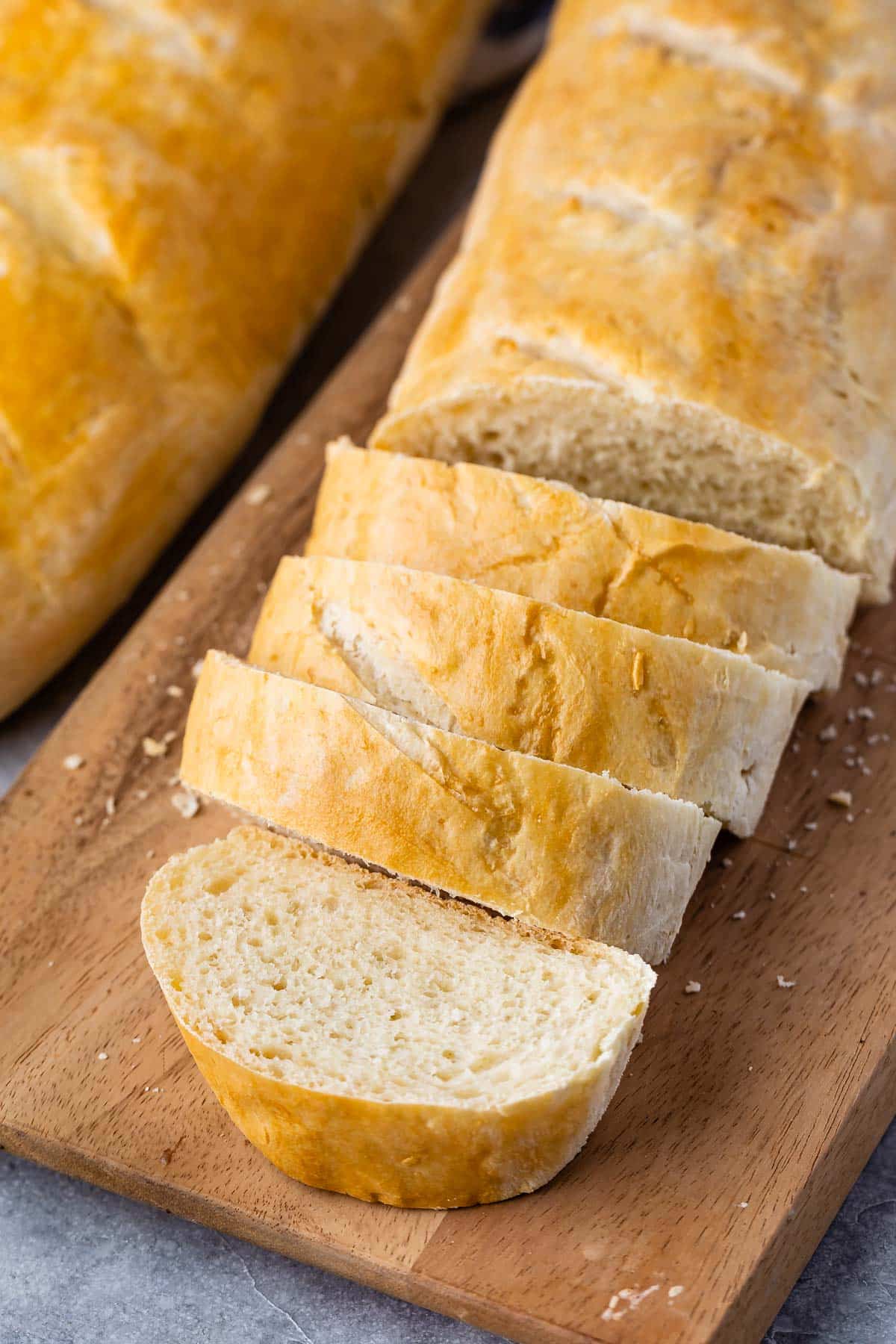 sliced loaf of french bread with loaf behind