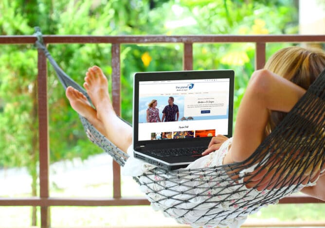woman laying in a hammock on her computer