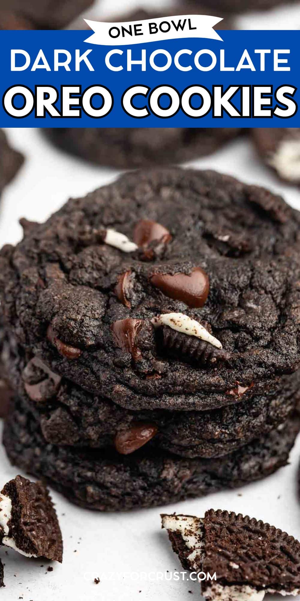 A close-up of a stack of Chocolate Oreo Cookies with chocolate chips and Oreo pieces, set on a white surface. Text at the top reads One Bowl Dark Chocolate Oreo Cookies.