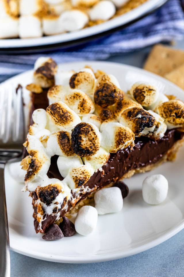 Slice of S'mores pie on a white plate with silver fork