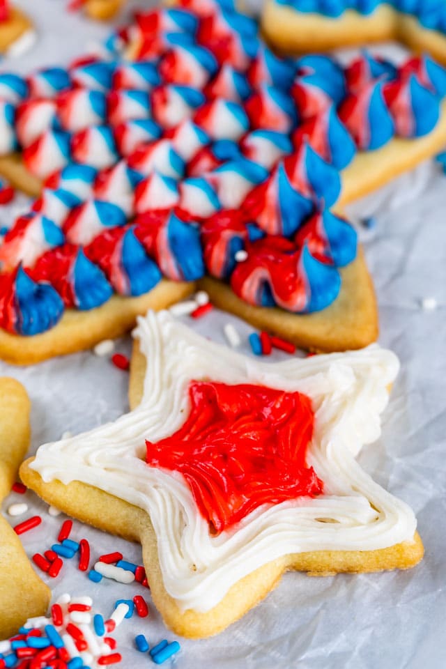 overhead shot of star shaped sugar cookies decorated with red, white and blue frosting