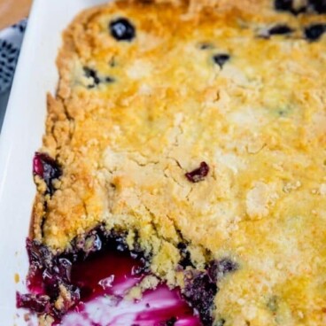 overhead shot of blueberry cobbler in pan with color blocks and words above and below it