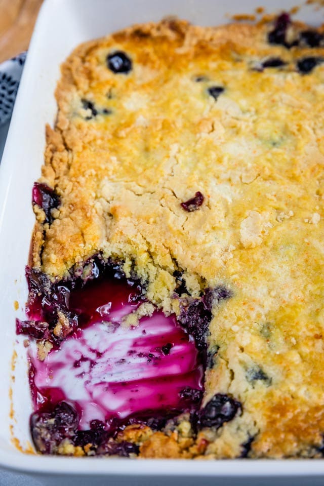 overhead shot of blueberry cobbler in pan with slice missing