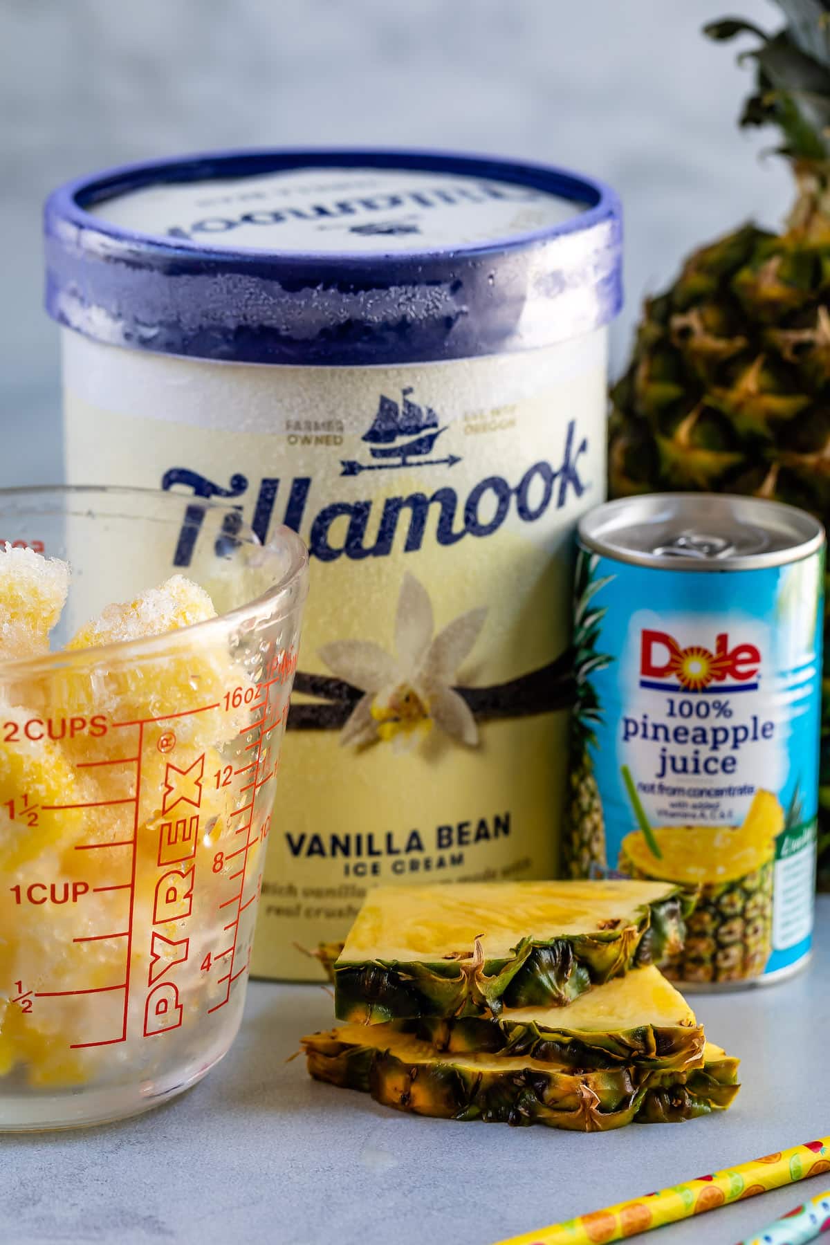 ice cream, cup of pineapple and pineapple juice can.