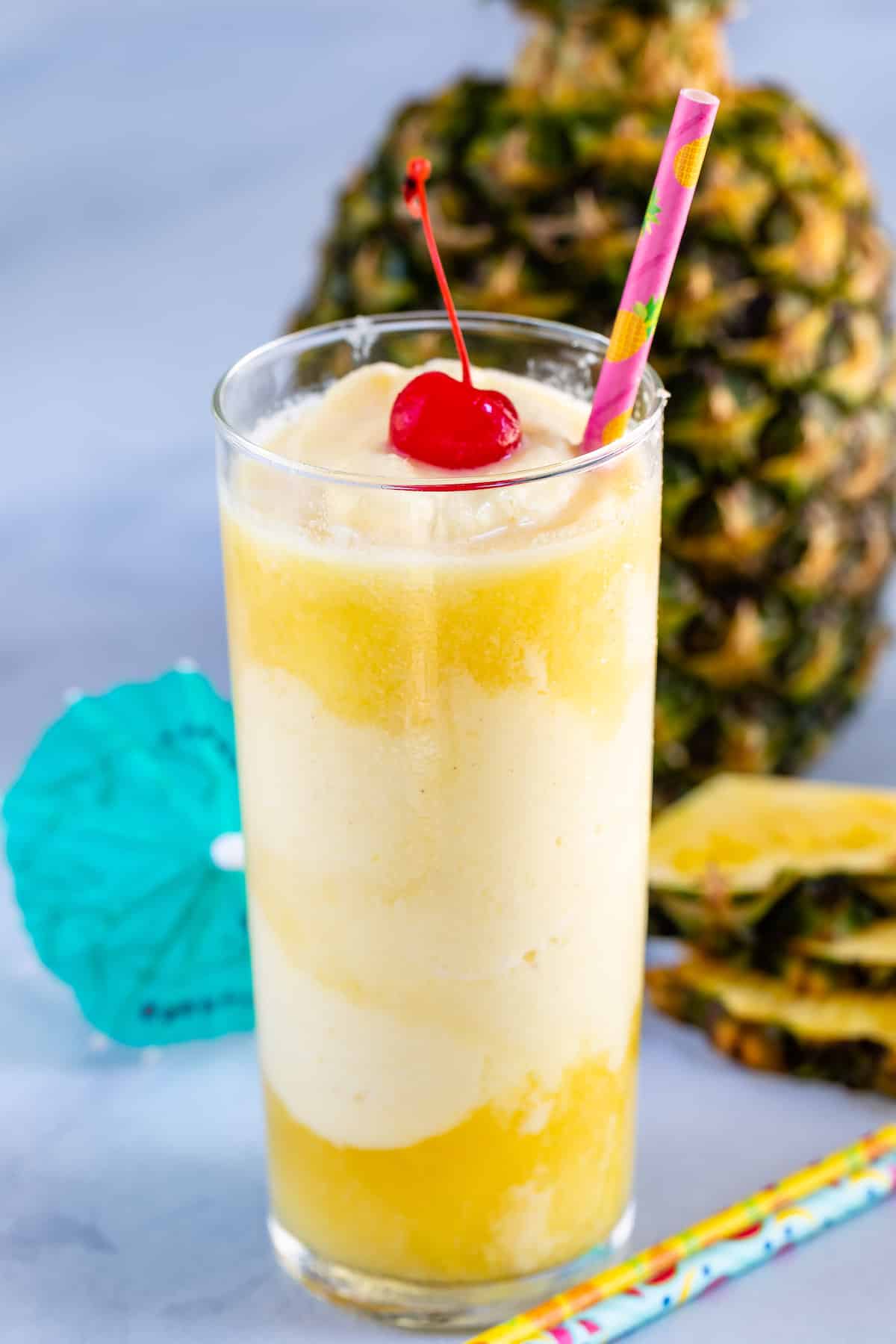 tall glass with dole whip and pineapple juice and cherry.