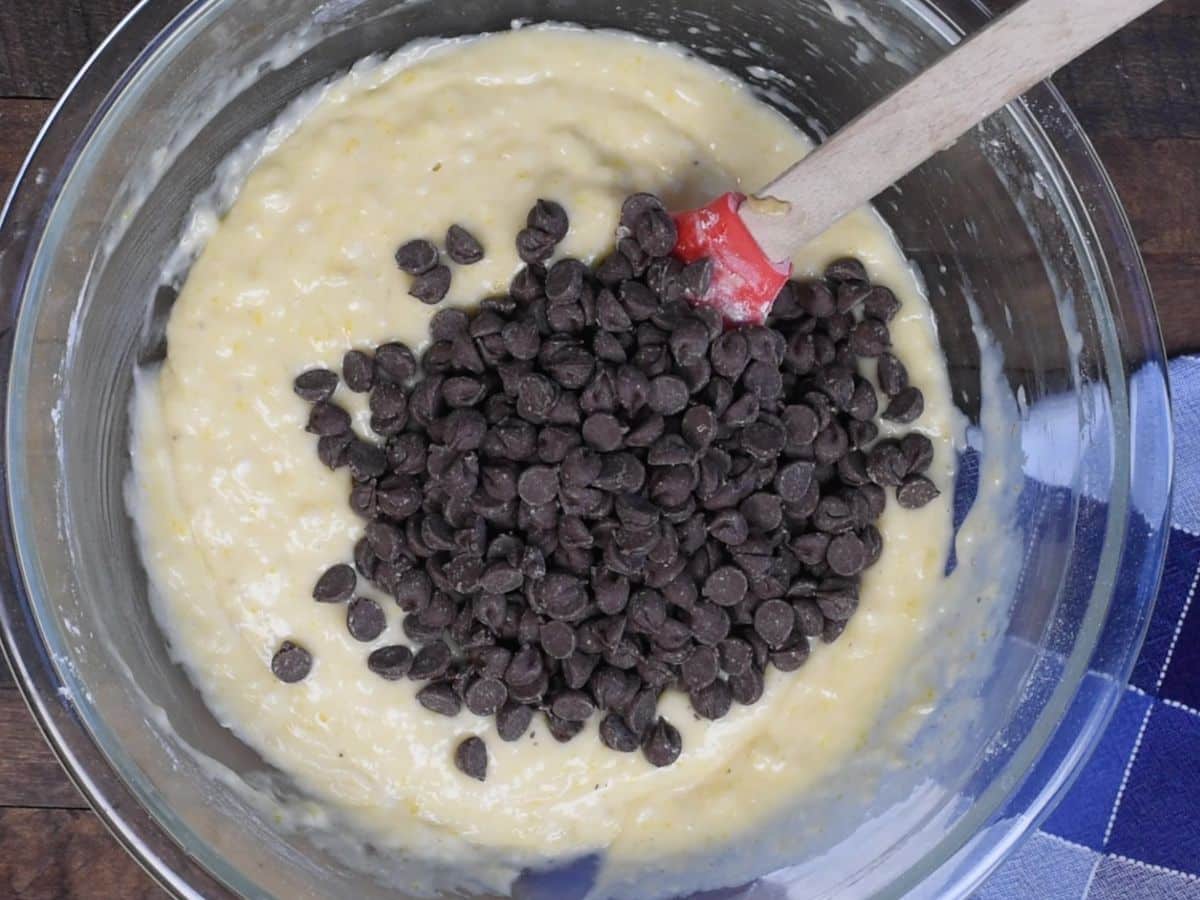 bowl of banana bread batter with chocolate chips and spatula