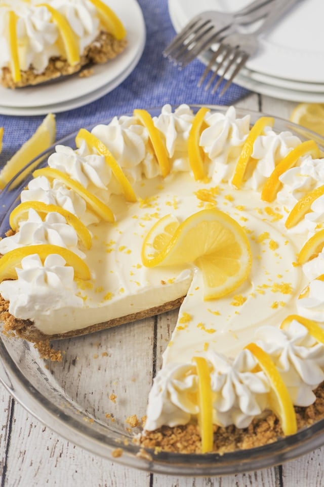 No bake lemon pie in a glass pie dish with one slice missing