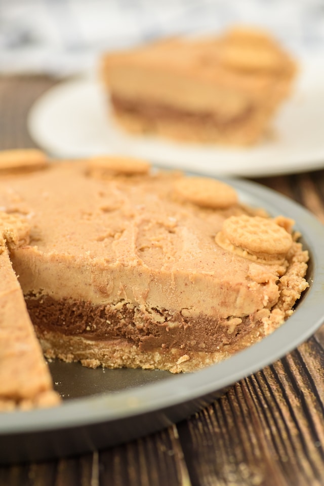 Side shot of nutella peanut butter pie with slice missing and on plate in background