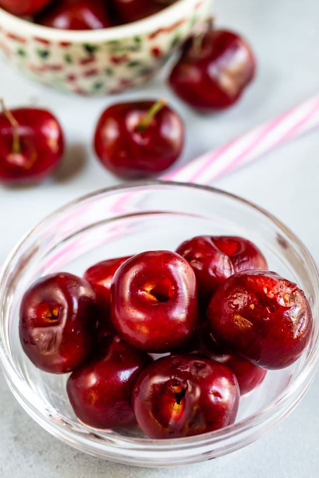Overhead shot of pitted cherries in glass bowl