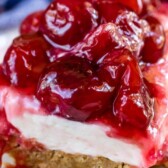 Slice of cherry delight on white plate with recipe title on top of image
