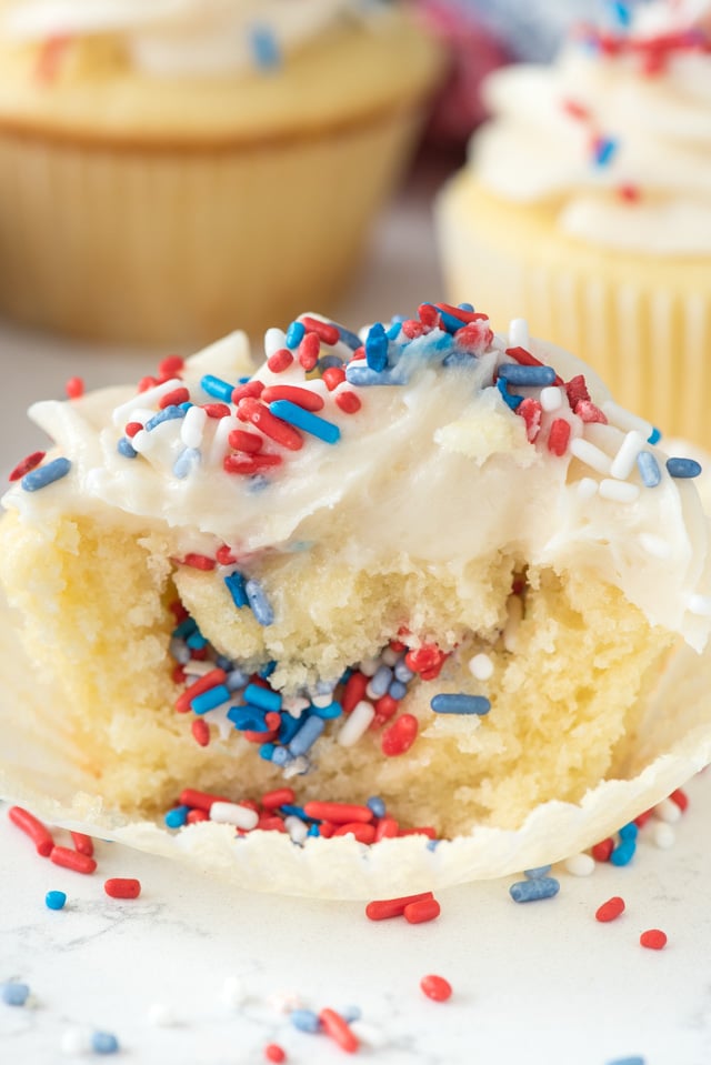 Fireworks surprise cupcake cut in half to show red white and blue sprinkle surprise in middle