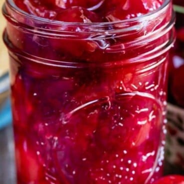 Cherry pie filling in a mason jar with recipe title on top of photo