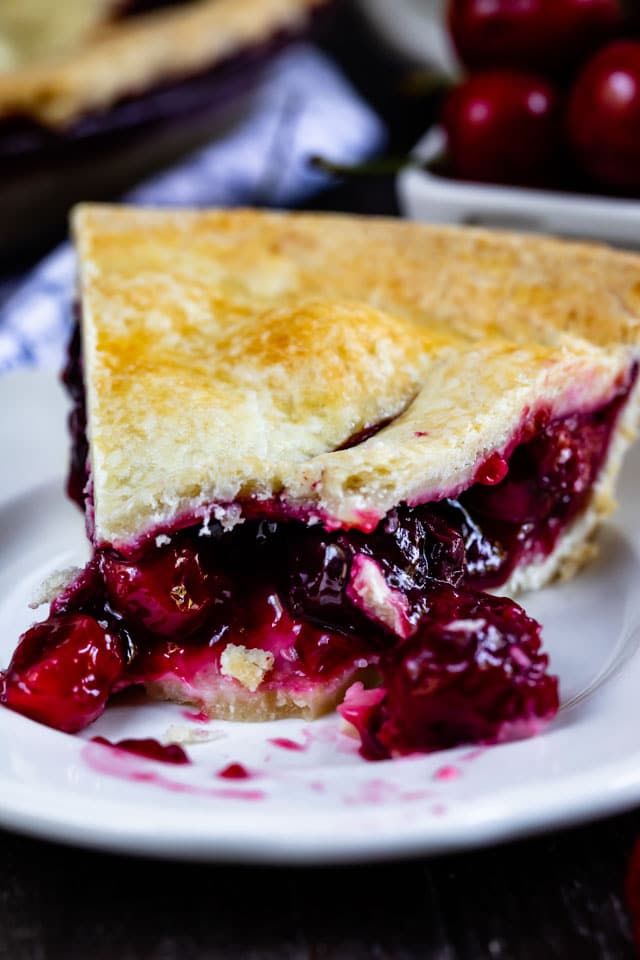 Close up shot of cherry pie slice with one bite taken out