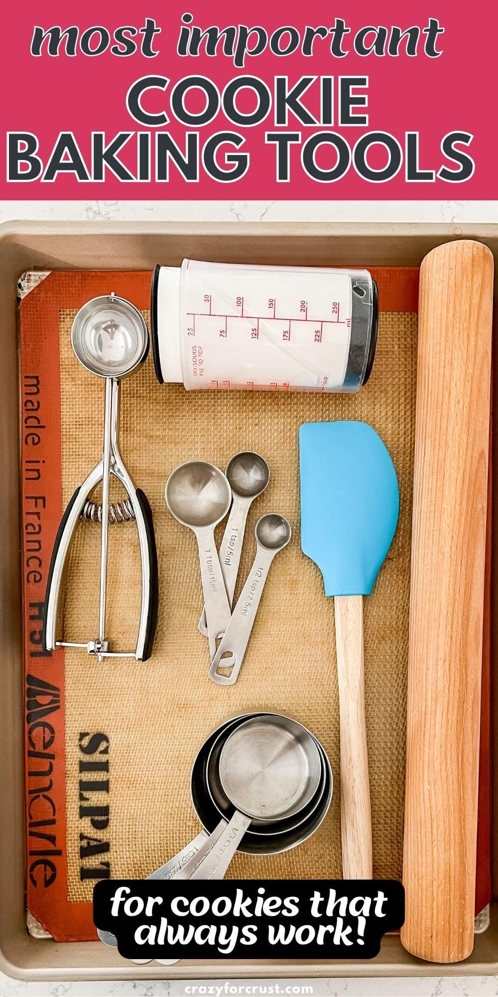 overhead shot of cookie sheet with silpat, cookie scoop, measuring cups, measuring spoons, rolling pin