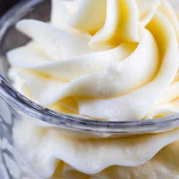 Vanilla buttercream swirled in a glass dish with recipe title on top