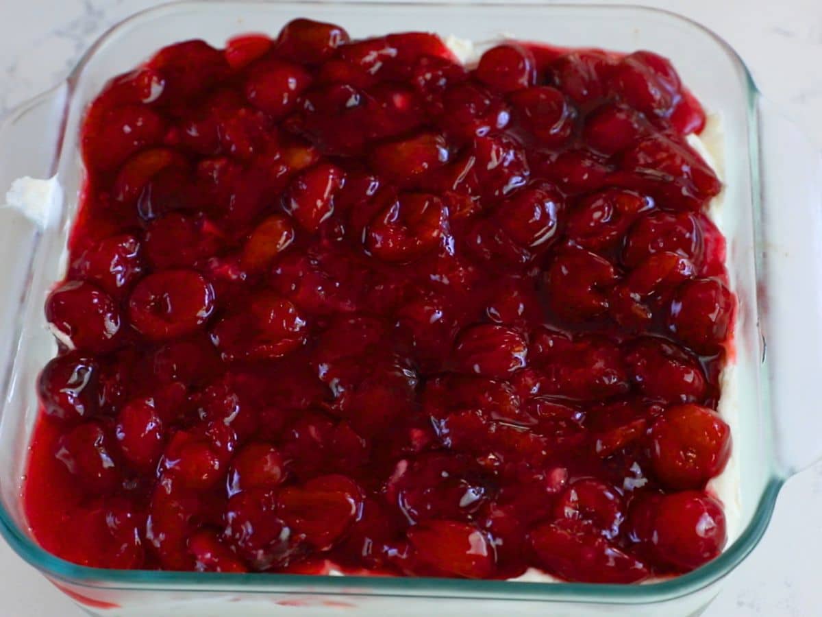 cherry pie filling on top in square pan.