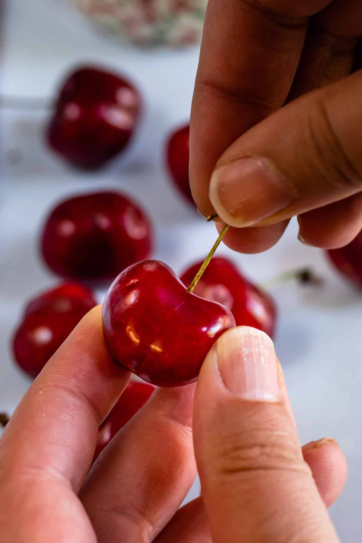 cherry with hand removing stem