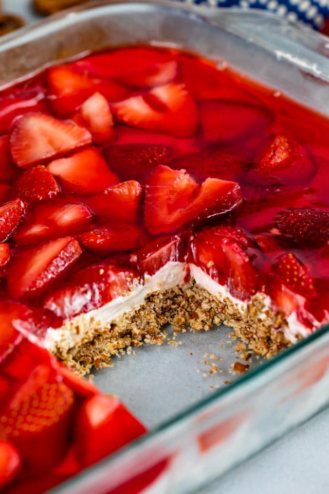 Strawberry pretzel salad in glass baking dish with one square missing