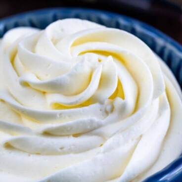 Whipped cream frosting in a blue bowl with recipe title on top