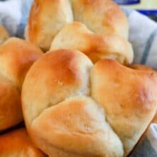 Close up of cloverleaf dinner rolls in a roll basket with recipe title on top