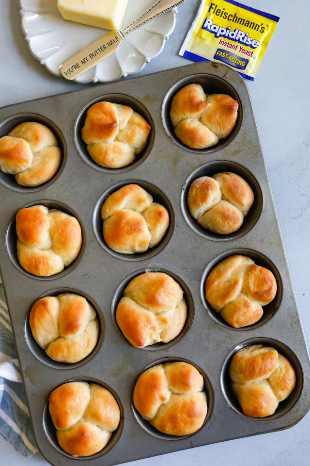 Overhead shot of baked cloverleaf dinner rolls still in muffin pan