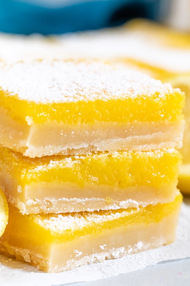 Close up photo of stack of three lemon bars on a paper towel