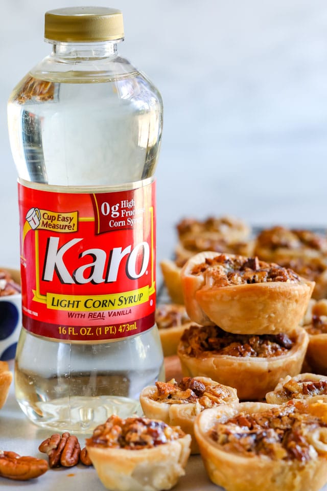 Mini pecan pies all over next to karo light corn syrup bottle