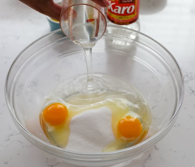 Mixing the sugar, eggs and light corn syrup in a clear mixing bowl