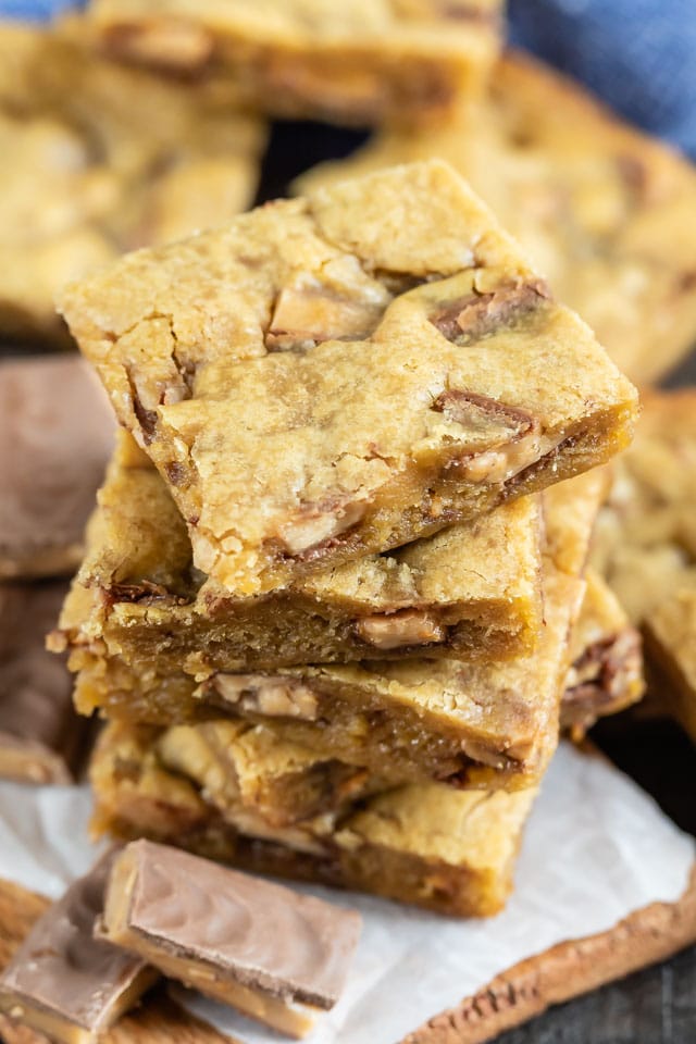 Overhead view of stacked toffee blondies with bits of toffee around