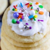 Stack of the best sugar cookies with icing and colorful sprinkles on top with recipe title at top of image
