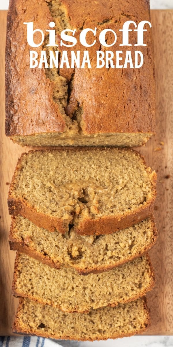 Overhead shot of biscoff banana bread loaf half sliced on wood cutting board with recipe title on top