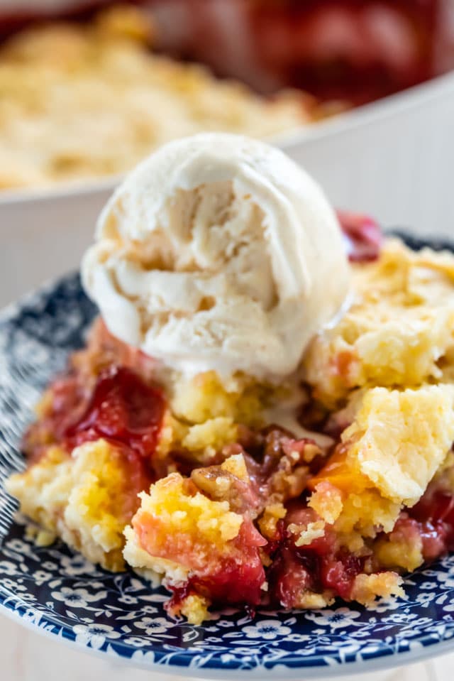 dump cake with cherries on blue patterned plate with ice cream