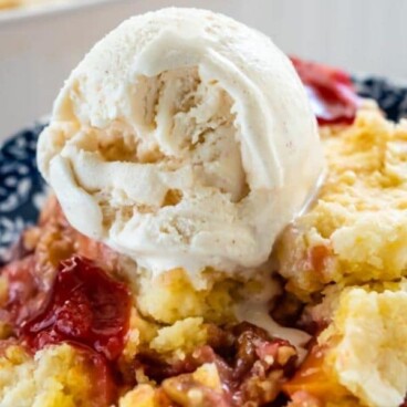 dump cake with cherries on blue patterned plate with ice cream