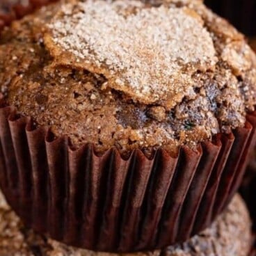 Two chocolate zucchini muffins stacked with recipe title on top