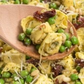 bowl of pesto tortellini with spoon holding some and words on photo