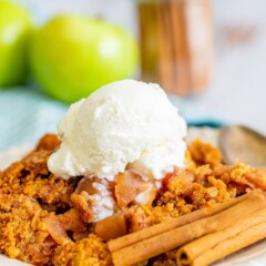 Apple dump cake on a white plate with a scoop of ice cream on top