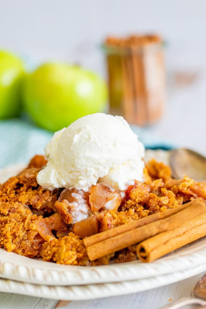 Apple dump cake on a white plate with a scoop of ice cream on top