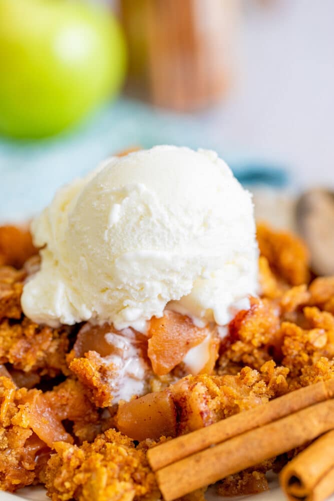 Close up shot of apple dump cake on plate with vanilla ice cream on top