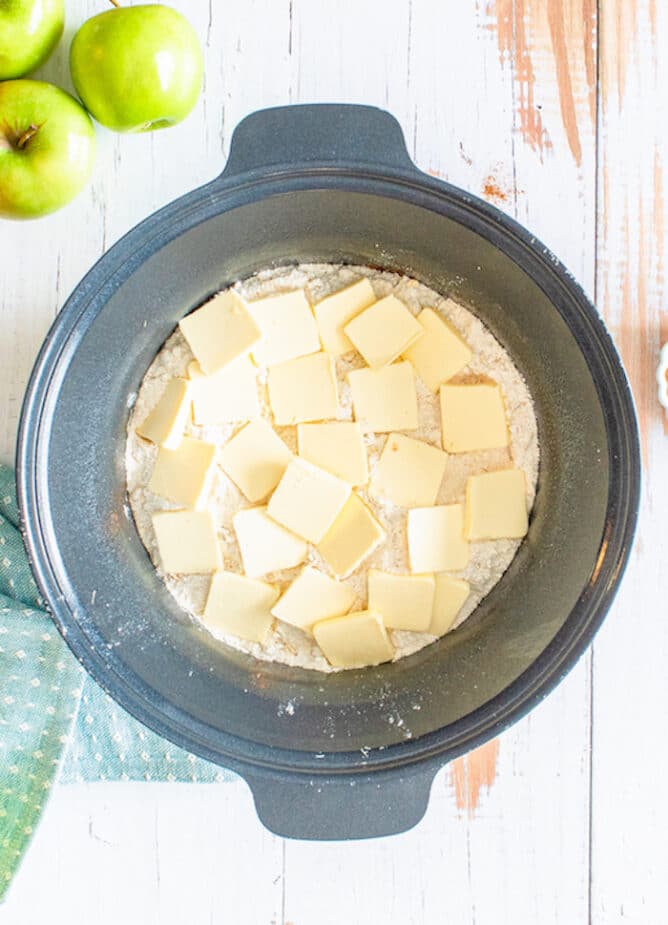 Overhead shot of cake mix and butter in slow cooker