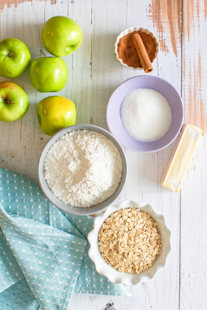 Overhead shot of apple dump cake ingredients in bowls on a wooden table
