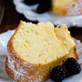 slice of pound cake on white plate with blackberries