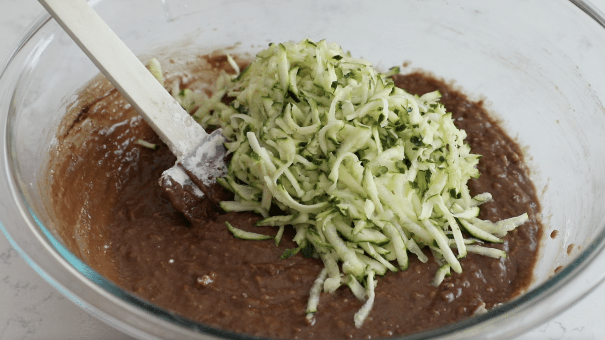chocolate batter in bowl with shredded zucchini.