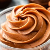 Chocolate cream cheese frosting in a glass dish with recipe title on top